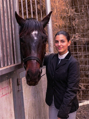 Fotografía original de una amazona junto a su caballo en el establo con sobrecarga de tonos rojizos y magenta
