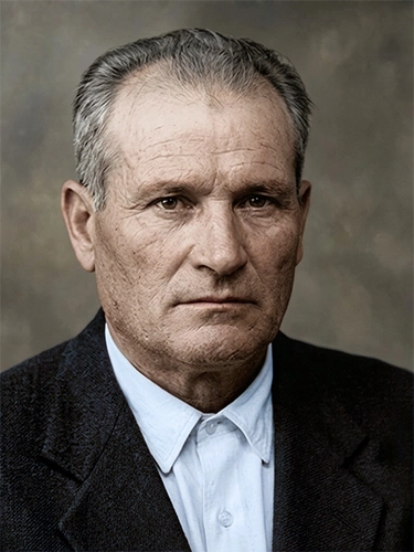 Retrato de primer plano de un hombre mayor con americana oscura y camisa de vestir blanca.