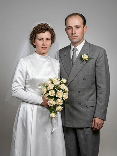 Fotografía de boda restaurada a color de una pareja posando con el ramo de novia.