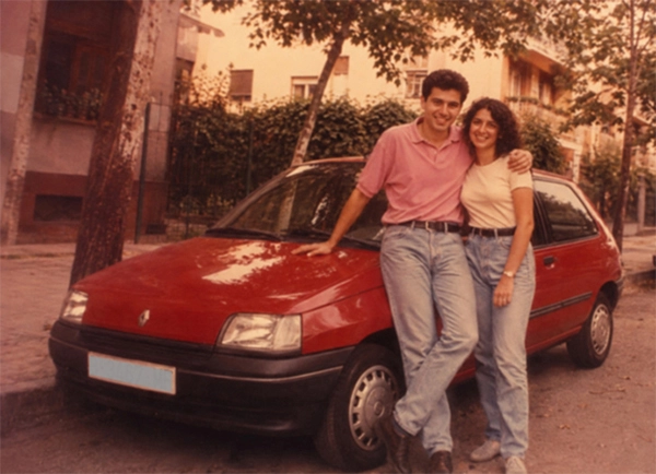 Pareja joven posando frente a su nuevo Renaulta Clío en los años 90