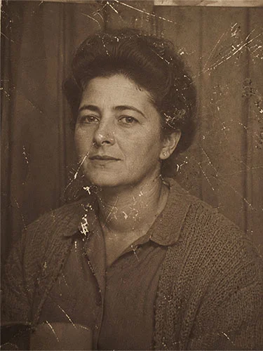 Retrato antiguo con arañazos superficiales que muestra a una mujer con camisa y chaqueta de lana.